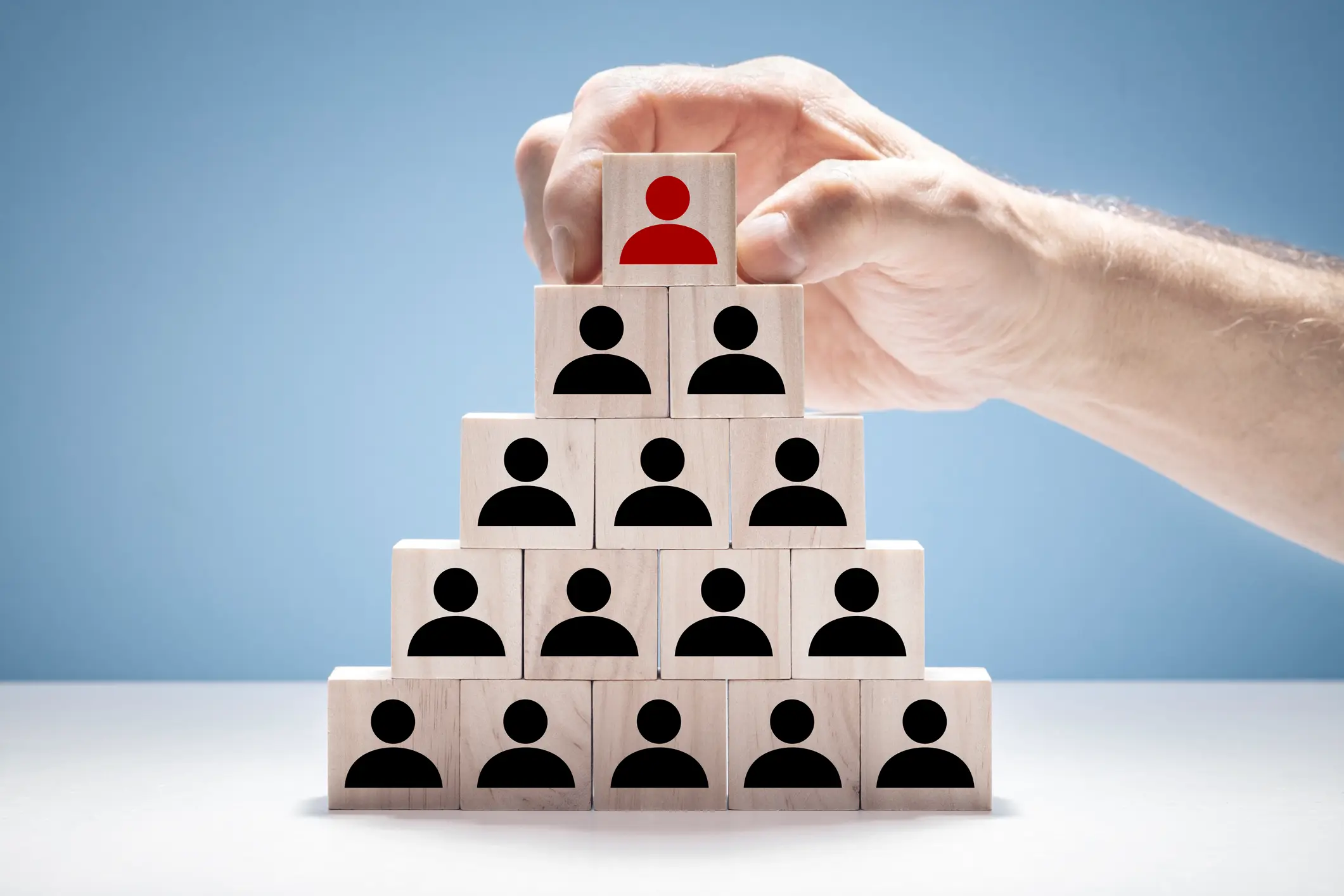 Wooden cubes of people, showing a recruitment headhunting process