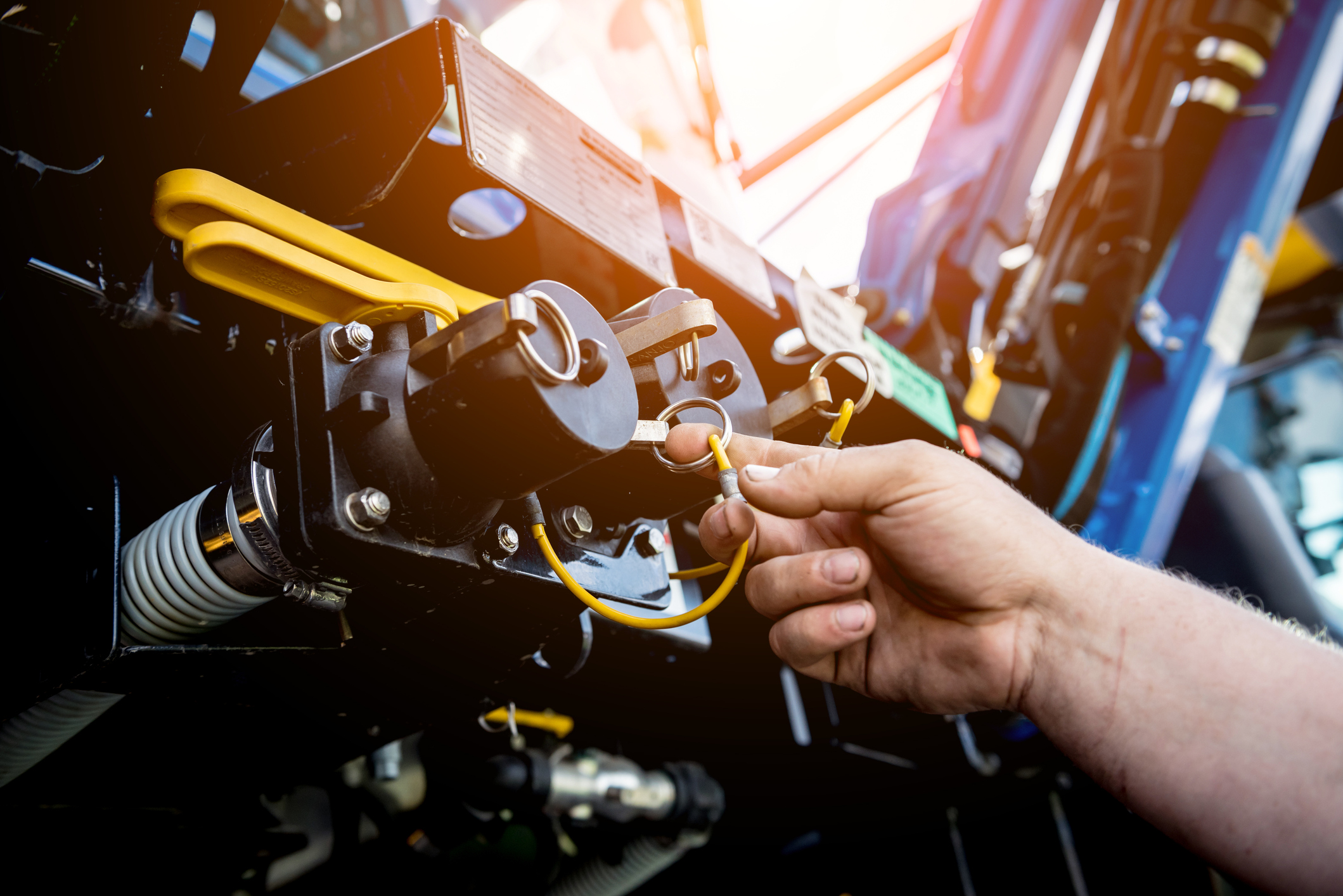 Hand touching an agricultural harvester engine