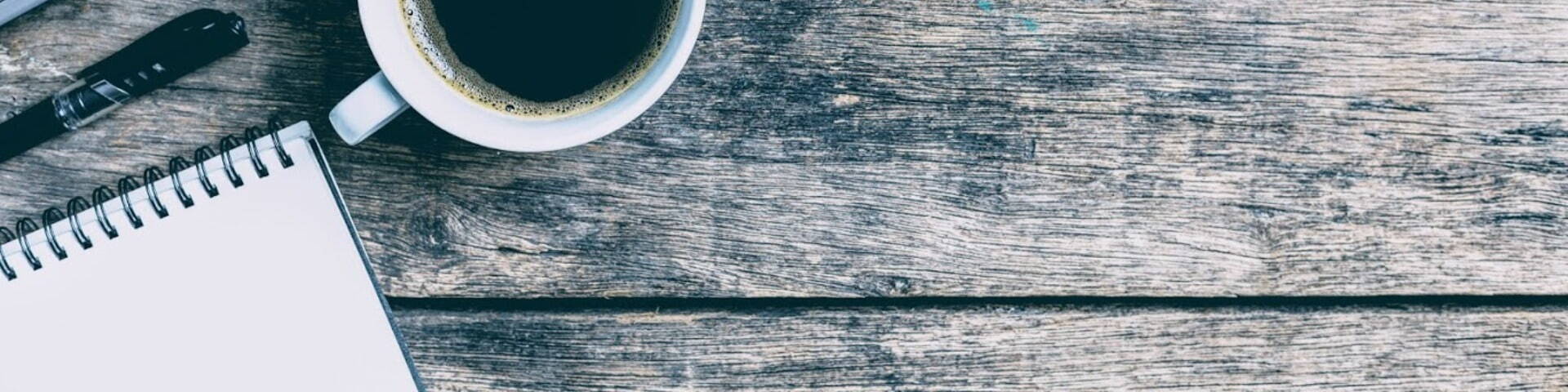 wooden desk with coffee pad and pen